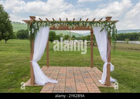 Elegant Outdoor Wedding Canopy with Floral Decorations in a Scenic Setting Stock Photo