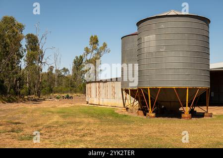 Landscape scene of farming equipment and metal grain storage silos in outback Australia. Stock Photo