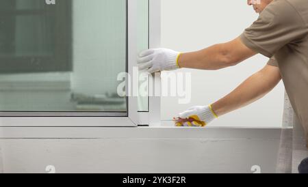 Construction worker repairing the sliding window. Stock Photo