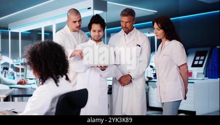 Medical Research Laboratory. Employees Talking In Lab Using Laptop Stock Photo