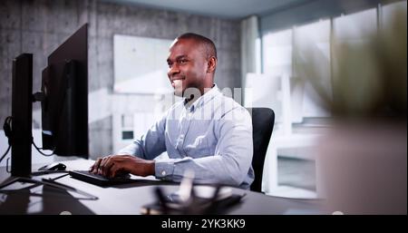 Employee Working On Desktop Computer In Home Office Stock Photo
