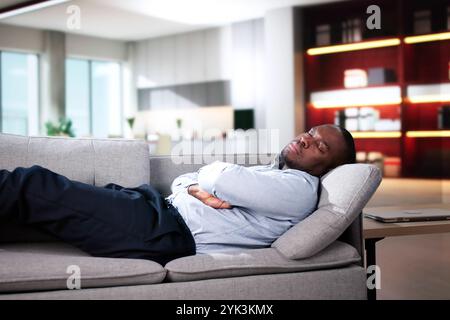 Young Man Relaxing On Sofa In Living Room Stock Photo