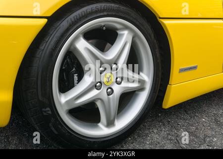 Close up detail of the alloy wheel of a giallo modena yellow Ferrari F355 Berlinetta Italian sports car produced from 1994 to 1999. Stock Photo