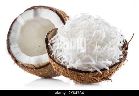 Grated coconut pulp in cracked coconut shell and half of split coconut on white background. File contains clipping path. Stock Photo