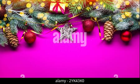 Christmas decoration with fir branches arranged as a frame on fuchsia background. Lay out. Stock Photo