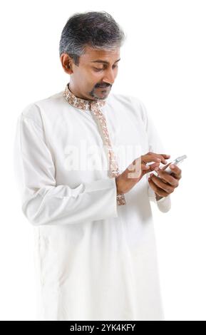 Mobile online / texting / sms Mature Indian male using mobile phone to online / texting / sms , isolated on white background Copyright: xZoonar.com/sz Stock Photo