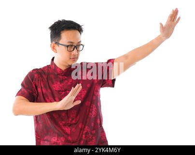 Practicing Tai Chi Southeast Asian Chinese man practicing tai chi, isolated on white background Copyright: xZoonar.com/szefeix 1053985423st Stock Photo