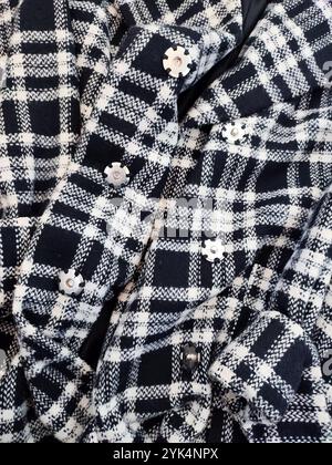 Plaid coat with metal buttons closureclose up, black white checked plaid coat, fabric, textile, clothes details, flat lay, clothing store Stock Photo
