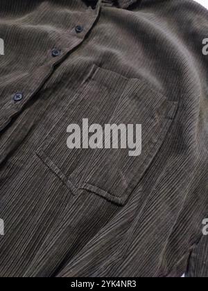 Corduroy, dark green khaki velvet shirt with pocket close up, textile, cotton, textured fabric, clothes, sewing, fashion, clothes store, manufacturing Stock Photo