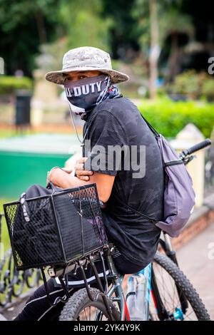 A young Filipina man takes a break from cycling in Rizal Park, Manila, The Philippines. Stock Photo