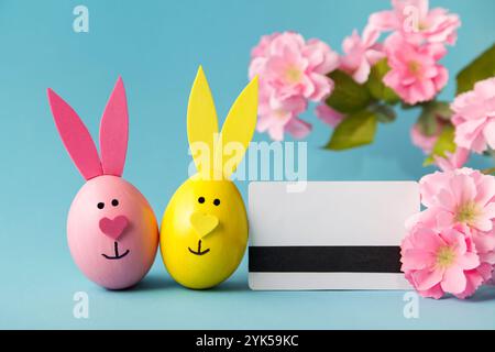 Shopping online. Ordering Easter. Easter eggs, bunny, credit card on blue background. Online store. Sale concept Stock Photo