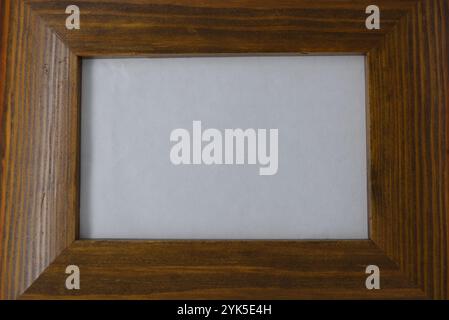 Beautiful and aesthetic photo frame is located on a white background. The frame is made of natural wood covered with varnish. Stock Photo