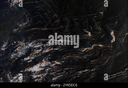Luxurious black marble texture featuring intricate white and brown veining. Stock Photo