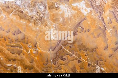 Intricate natural stone texture in warm tones of orange, brown, and hints of white. Stock Photo