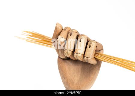 whole wheat spaghetti in a wooden hand on a white background Stock Photo
