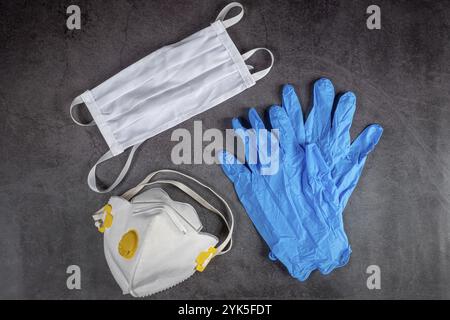 Protective medical mask, respirator and gloves on black background. Protective equipment against pollution, virus, flu and coronavirus, covid 19 Stock Photo