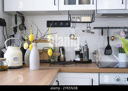 Interior of kitchen and details of decor of utensils with Easter decoration of colorful eggs in a loft style. Festive interior of a country house Stock Photo