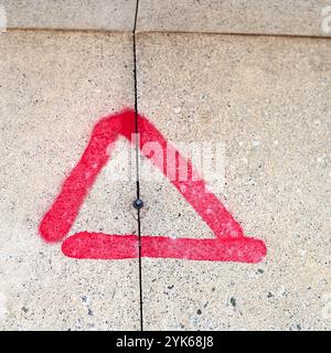 Metal screw  needing removal protruding  from wall  marked with red triangle Stock Photo