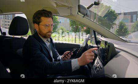Business man inside modern electric car travel driving automobile in city displeased confused driver road destination auto navigation error worried Stock Photo