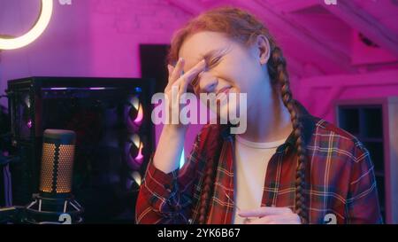 Caucasian woman girl unwell female teen gamer streamer influencer blogger coder programmer neon night overwork computer play video game typing online Stock Photo