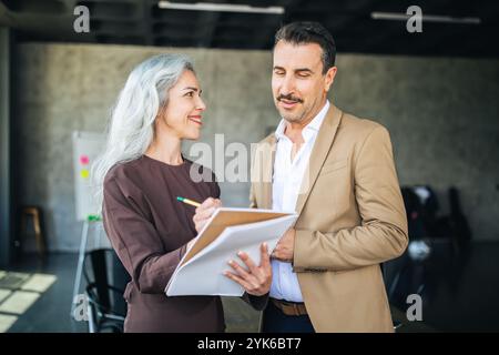 Professionals discussing ideas in a modern office setting during the day Stock Photo