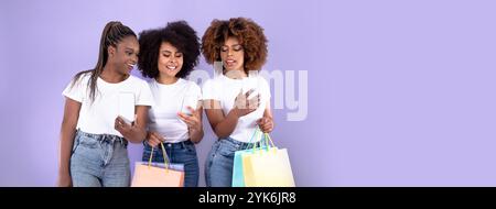 Three friends enjoy shopping together while checking their phones in daylight Stock Photo