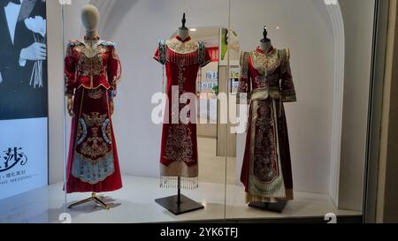 A showcase of three traditional Chinese wedding dresses on mannequins. Stock Photo