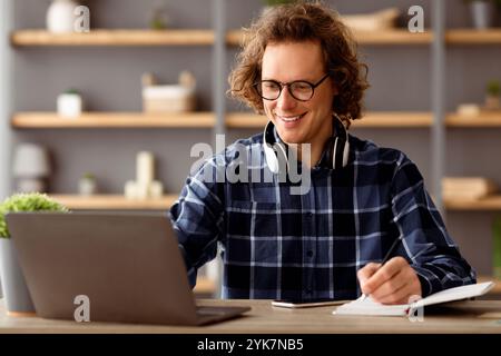 Young Businessman At Laptop Taking Notes Working In Modern Office Stock Photo