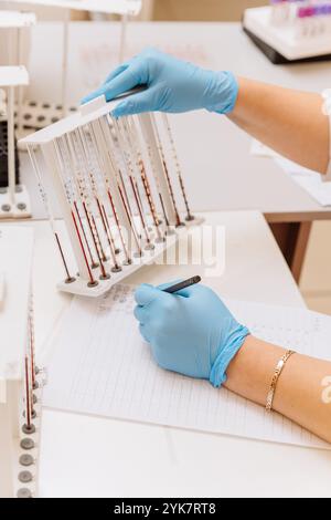 Lab technician analyzing blood samples for medical testing in a modern laboratory setting Stock Photo