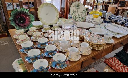 A stunning collection of vintage tableware and decorative items displayed on a wooden table Stock Photo