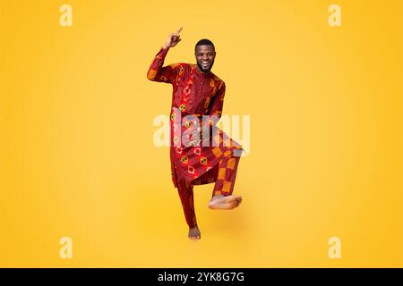 Cheery black guy having fun over yellow background Stock Photo