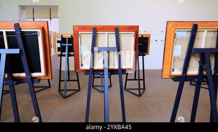 Wooden easels at a museum art exhibit seen from behind; rear view of paintings in wood frames. Stock Photo