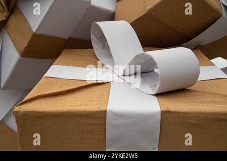Boxes wrapped with brown material and white bows tied on them. Stock Photo