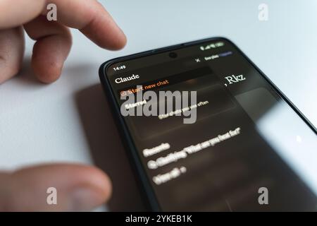 Person using Claude AI app smartphone. Large language model developed by Anthropic. Close up view Stock Photo