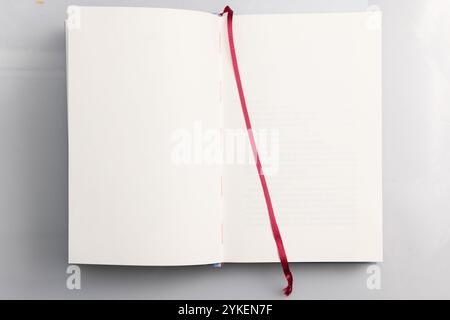 Opened book with blank pages and red ribbon isolated on white background. Mockup for content Stock Photo