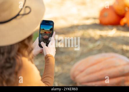Woman taking pictures of the pumpkin on pumpkin patch Stock Photo