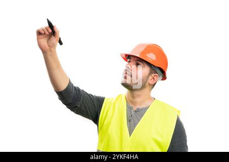 Serious trades construction workman wearing orange safety helmet and fluorescent vest using black marker for writing on blank copyspace isolated on wh Stock Photo