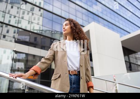 A poised Brazilian businesswoman stands confidently in a modern urban landscape, showcasing professional ambition and style Stock Photo