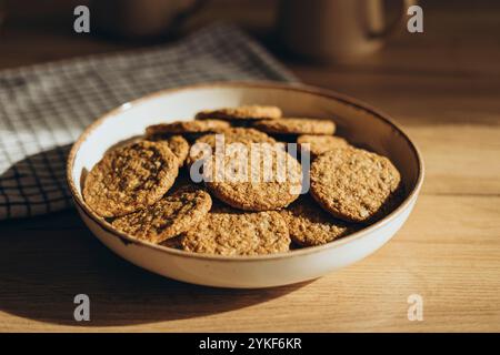 Bowl filled with homemade whole grain cookies without sugar, placed on a wooden table with subtle lighting. Stock Photo