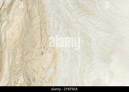 A natural background showcasing the intricate patterns of cracked mud, displaying various earthy tones and textures. Stock Photo