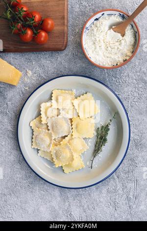 Freshly prepared ravioli stuffed with creamy goat cheese and sweet caramelized onions, served with tomatoes Stock Photo