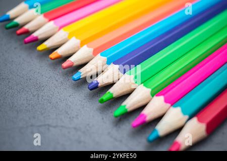 Set of colored pencils lined up on a gray background Stock Photo