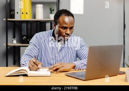Man working on laptop at desk. Stock Photo