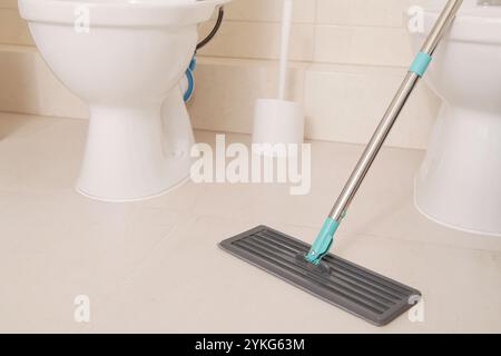 Cleaning Floor in Bathroom, WC. Mop close-up. Clean Surface Big Ceramic Tile floor . Copy space. Mock up Stock Photo