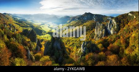 Colorful forest at sunset in autumn. Top view of mountain in woods. Beautiful landscape with  red and orange leaves in fall. Slovakia - Sulov Stock Photo