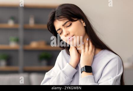 Portrait of woman massaging neck after work Stock Photo