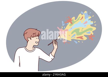 Cheerful male artist applying paint on wall drawing abstract colorful blots for interior decoration. Creative guy in white t-shirt creates trendy art Stock Photo