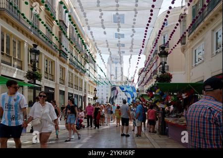 Festive Calle Larios, adorned with colorful decorations and bustling with visitors during the vibrant August Fair Stock Photo