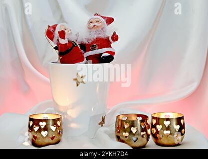 Two joyful santa figures standing in a ceramic pot Stock Photo