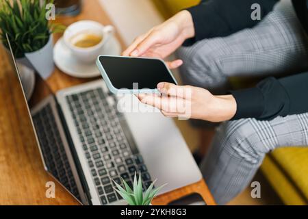 use smartphone laptop blank screen mockup home office interior electronic devices equipment green plants woodden coffee table cozy real estate Stock Photo
